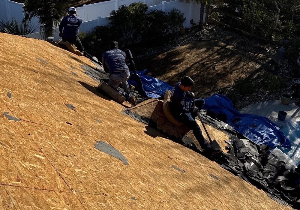 Coastline Roofing crew removing existing roofing during a roof replacement